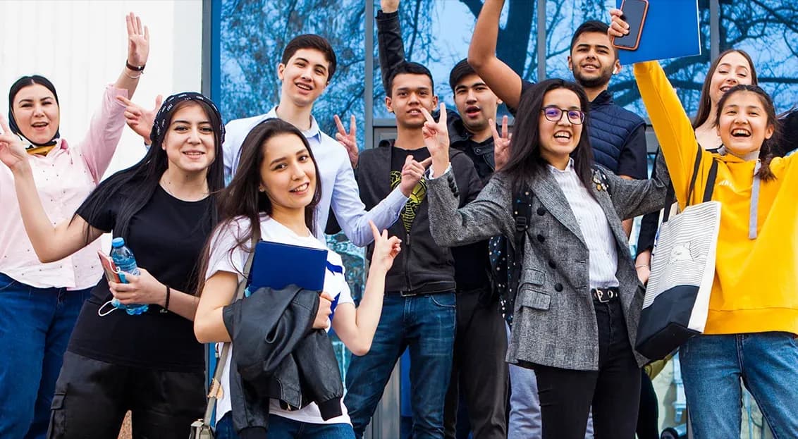 Students in front of Tashkent campus building, smiling
