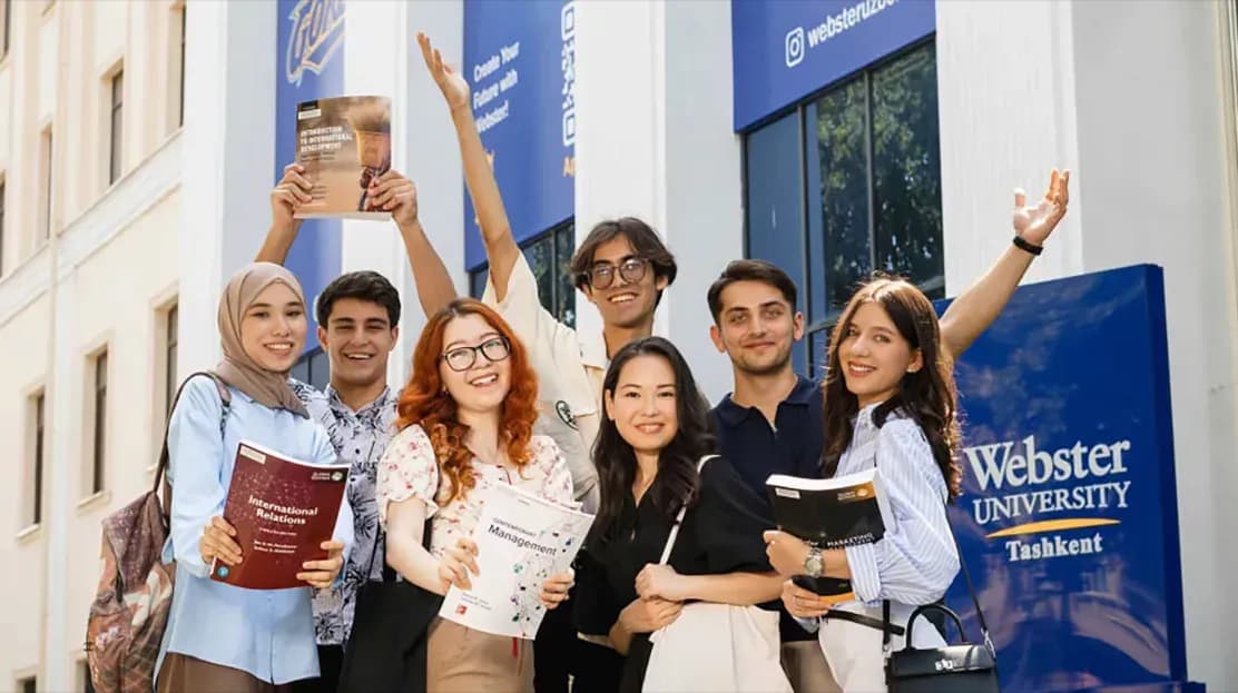 Several students standing in front of Tashkent building on campus.