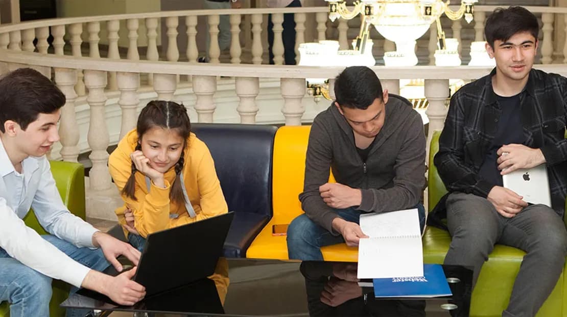 Four students studying together in a common room on campus.