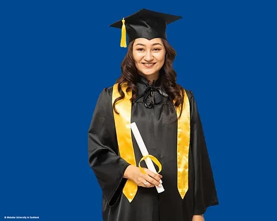 MBA Alumna Tursunoy Usmnonova looks into the camera in her commencement gown