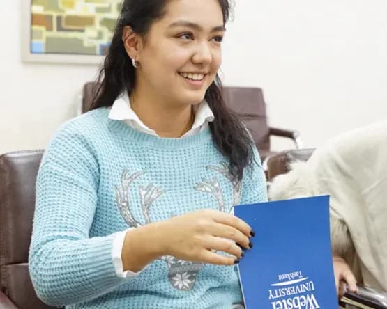 student flips through Webster Tashkent brochure