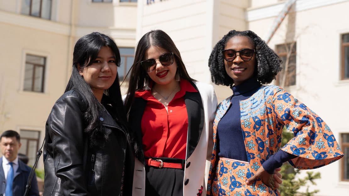 Three Tashkent students posing together.